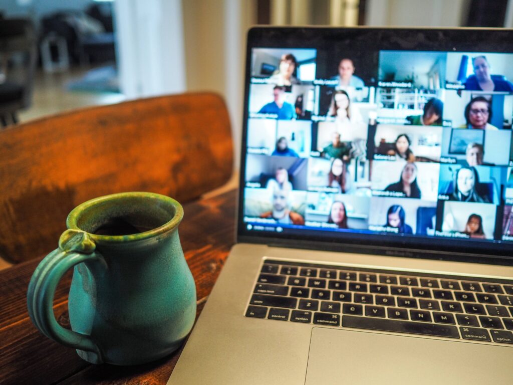 Laptop showing a video conference with lots of people 