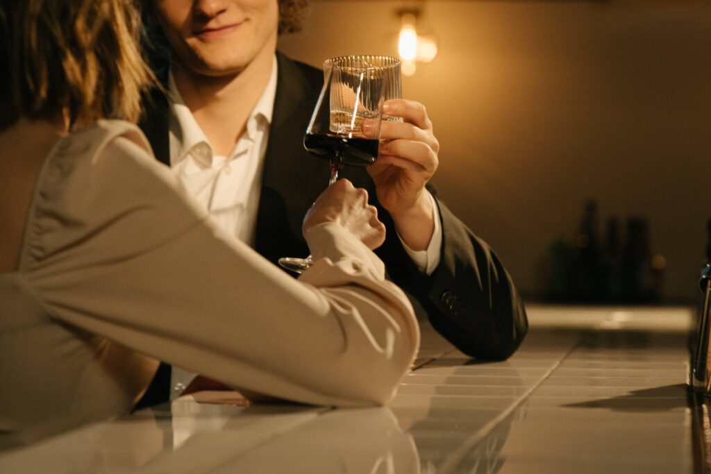 Man and woman clinking glasses at a bar