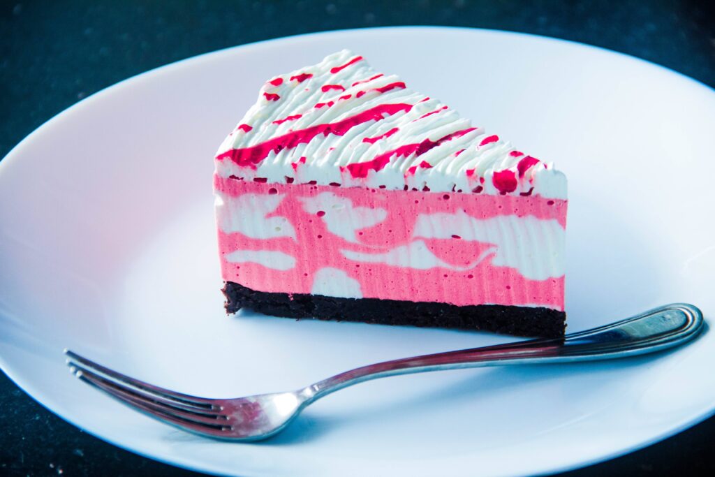 Pretty slice of marbled pink and white cake on a plate.